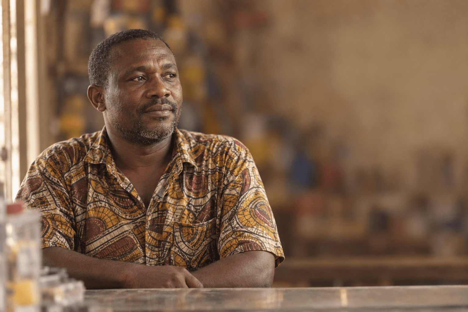 A shopkeeper behind the counter of his hardware shop.